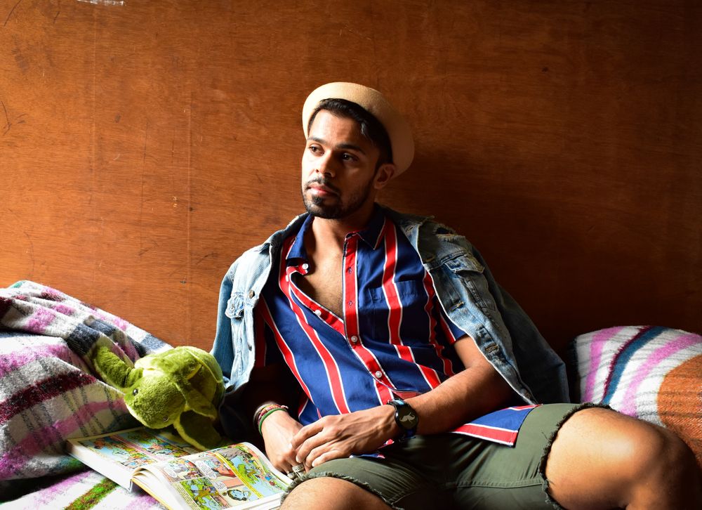 Man in striped shirt and hat sitting on couch