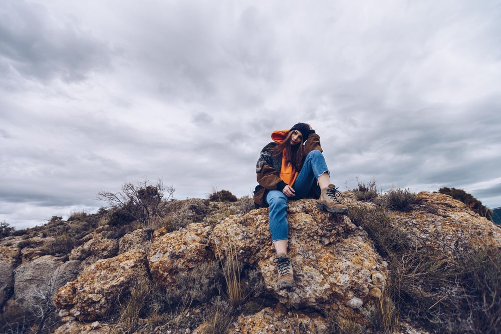 Cheerful woman resting on mountain top