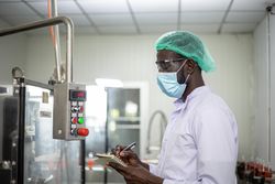 Man in hair net and PPE at food factory