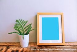 Wooden picture frame on desk with plant mockup bxlZdb