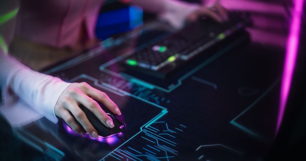 Female Gamer Sitting Behind a Futuristic Interactive Desk in a Colorful Neon Studio Room.