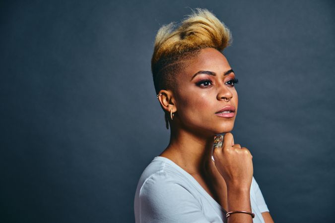 Profile of proud Black woman with short blonde hair with hand to her chin
