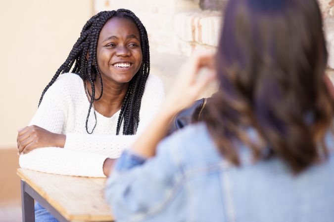 Female friends chatting on a table outdoors