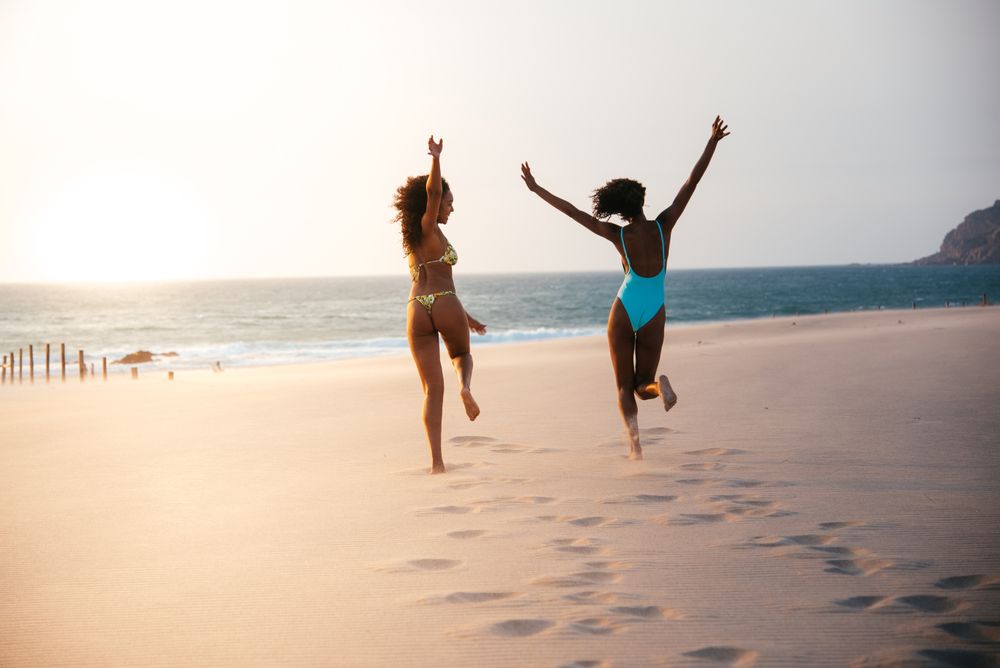 Unrecognizable women enjoying on beach in swimsuit
