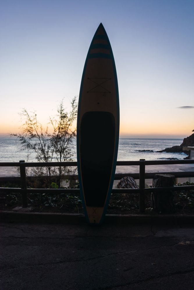 Man practicing paddle surfing with neoprene in a sunrise