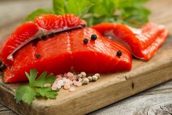 Fresh Copper River salmon fillets on rustic wooden server
