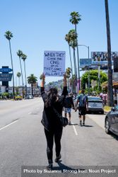 Los Angeles, CA, USA — June 14th, 2020: woman walking down city street at BLM protest 41ln75