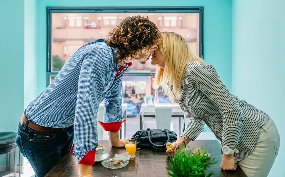 Couple kissing in a cafe