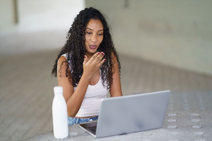 A Young Woman is Actively Engaged in an Online Conversation While Using Her Laptop