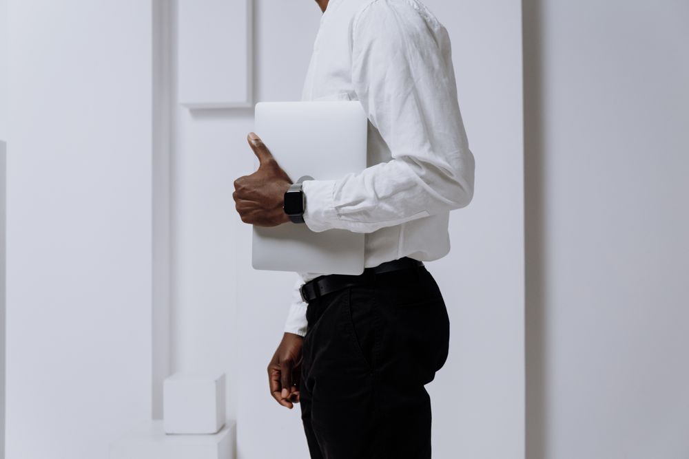 Side view of man holding a laptop