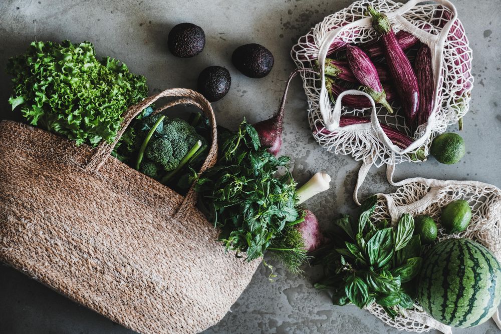 Overhead shot of full grocery shopping jute and mesh bags with fresh produce