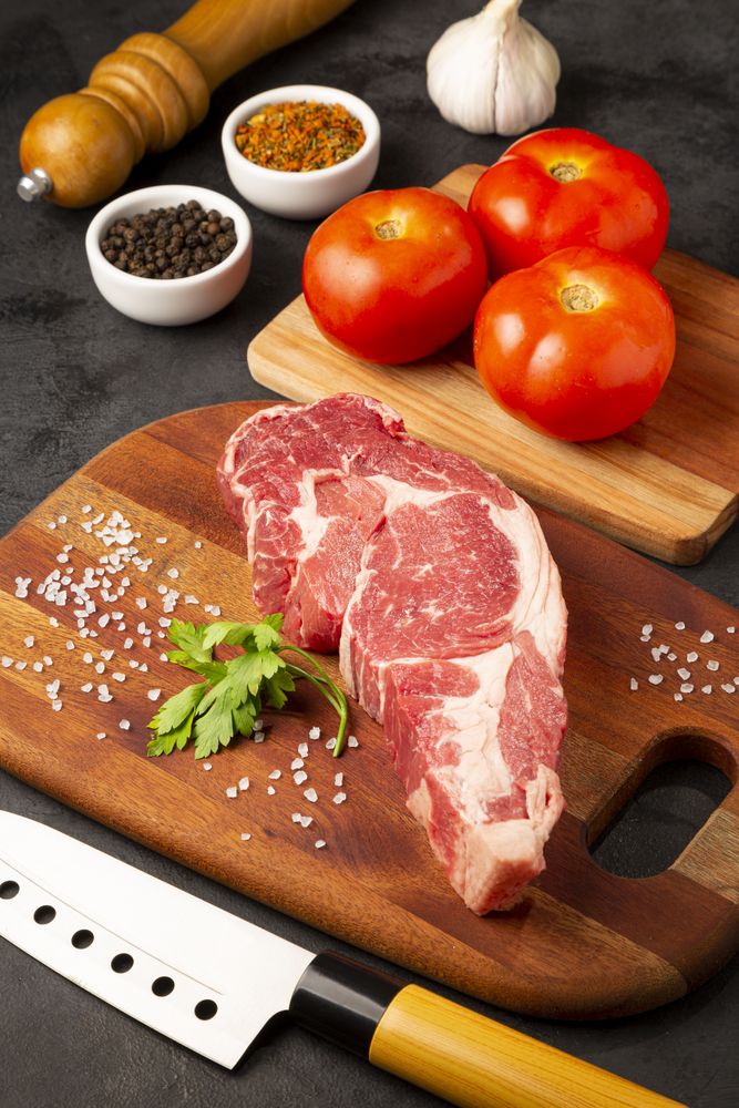 Raw ancho meat ready to roast on a wooden cutting board.