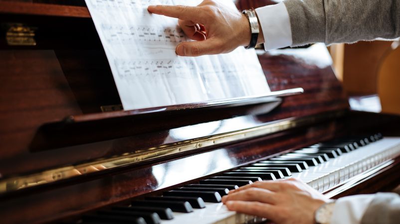 Crop male hands playing piano