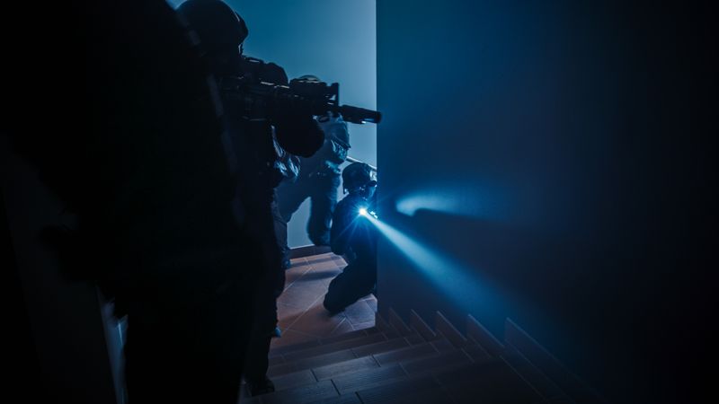 Soldiers with Rifles and Flashlights Move Forwards and Cover Surroundings.