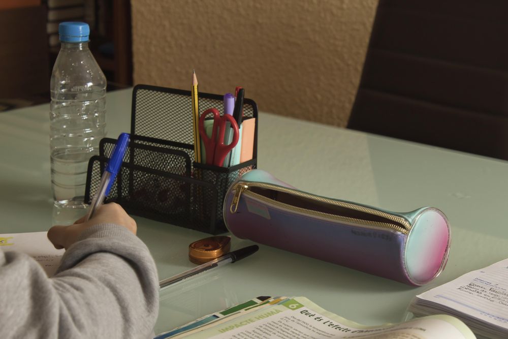 Cropped image of person studying and doing homework at home