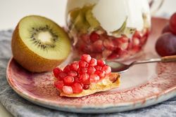 Delicious yogurt dessert with pomegranate, kiwi, grape and ginger biscuit