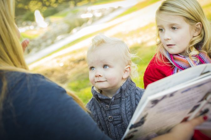 Mother Reading a Book to Her Two Adorable Blonde Children.