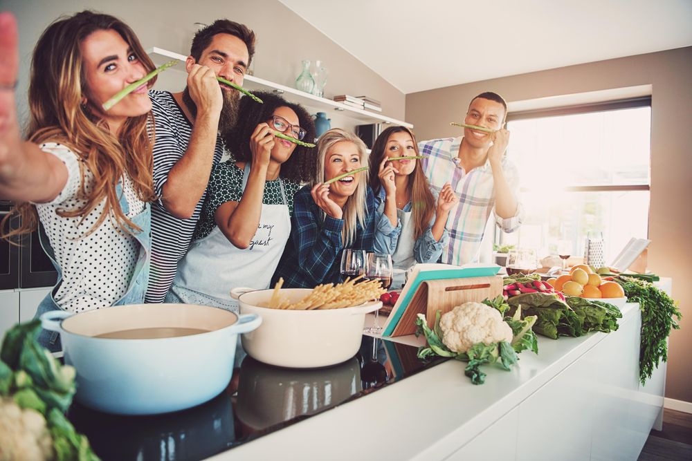 Multi-ethnic friends making goofy faces with asparagus