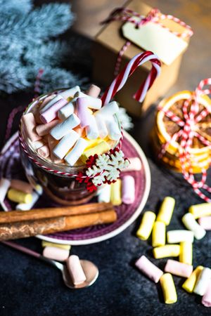 Marshmallow hot chocolate on table with red lantern and dried orange