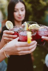 Group of cheerful friends clinking glasses at party