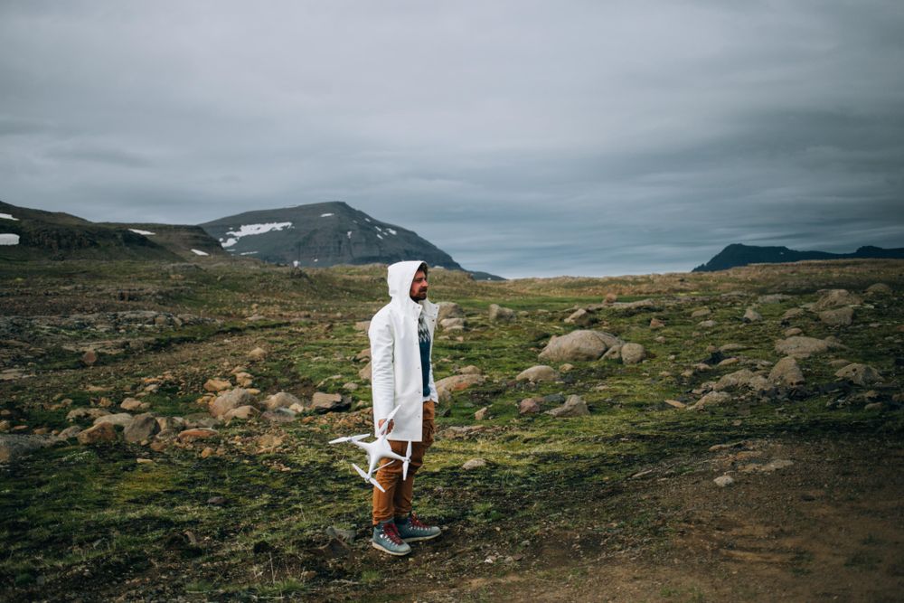 Man holding drone in rocky terrain