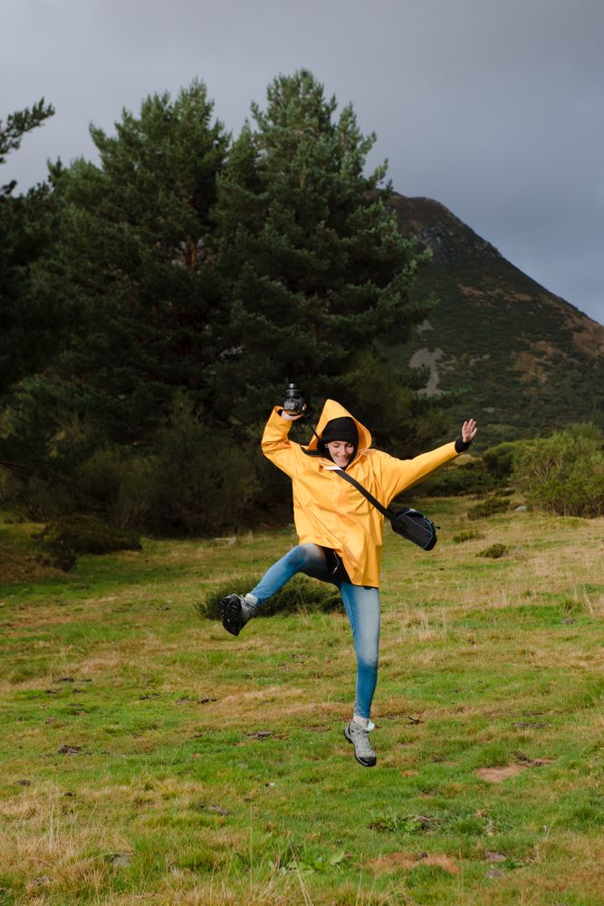 Person in yellow raincoat walking in forest
