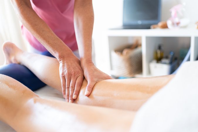 Masseuse working on calves of female client