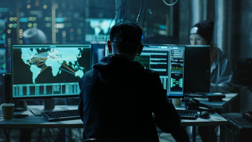 Back View of Hacker Working in Computer and Infecting with Virus Data Servers of Government Infrastructures.