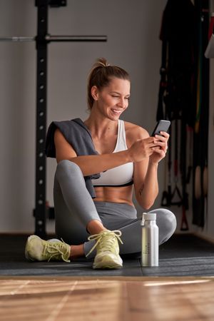 Sportswoman using cellphone in gym
