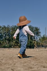 Anonymous little child strolling along paddock in ranch