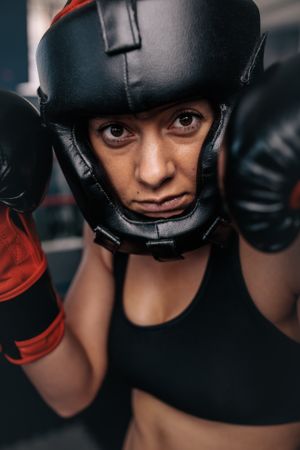 Portrait of female boxer in head gear & gloves