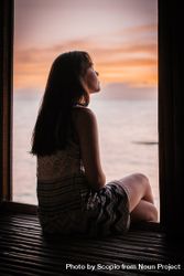 Woman looking at ocean during sunset 0LAvX5