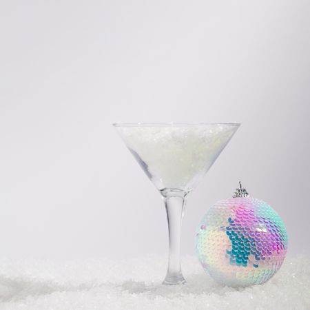 New Year disco bauble ornament and martini glass filled with snow