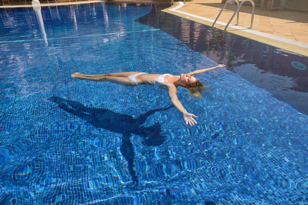 Female chilling while floating in pool water