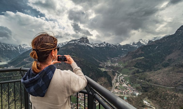 Traveler taking pictures of mountains from pier