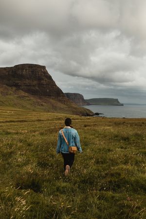 Serene tourist enjoying view of tranquil green valley in cloudy weather
