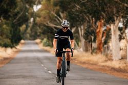 Woman smiling on bicycle in middle of road