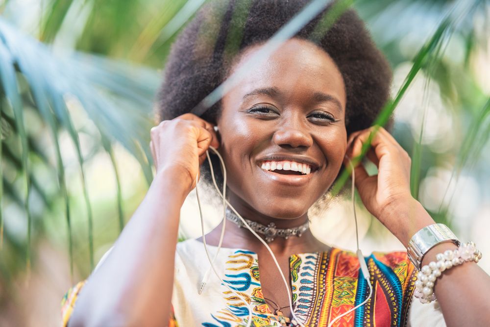 Smiling Black woman listening to music