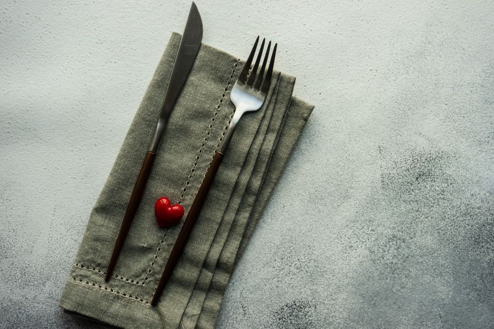Heart decoration on grey napkin and cutlery
