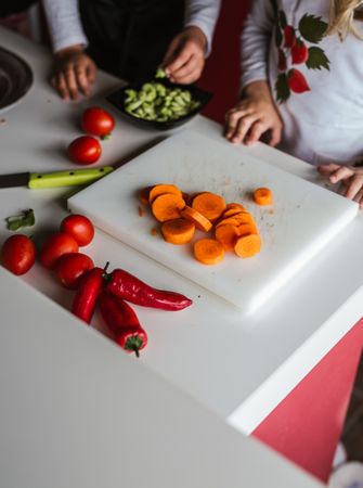 Anonymous kids preparing vegetables for salad