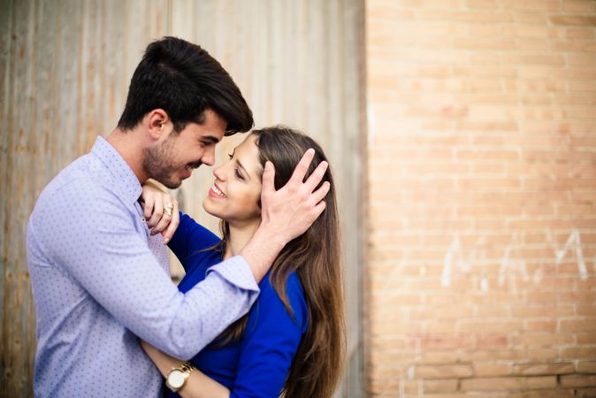 Amorous couple standing near columns
