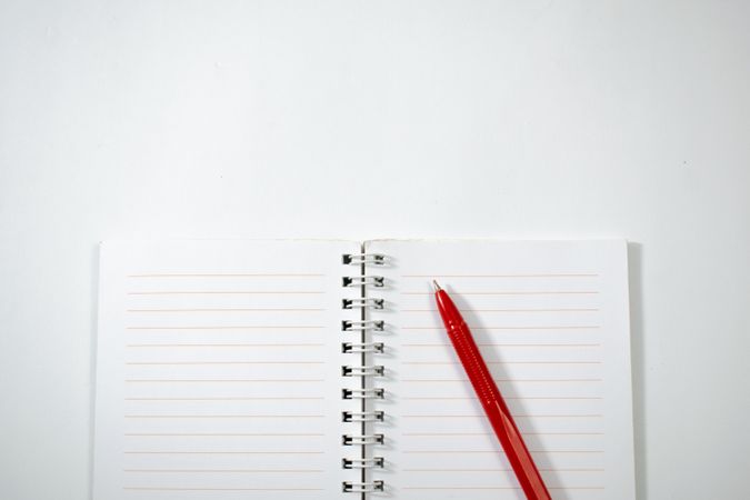 Open notebook and red pen isolated on plain background