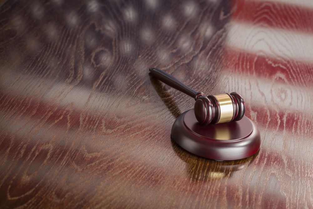 Wooden Gavel Resting on Flag Reflecting Table