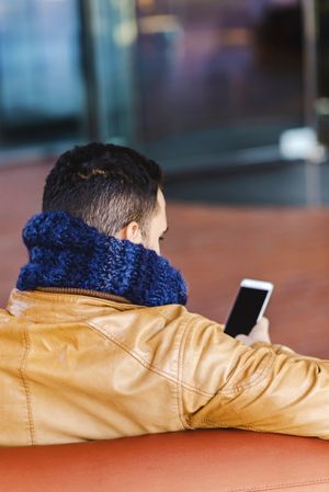 Stylish man using smartphone on couch