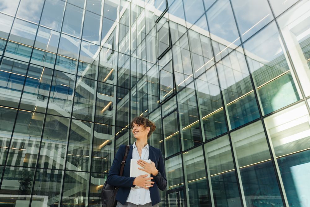 Positive businesswoman using tablet on street