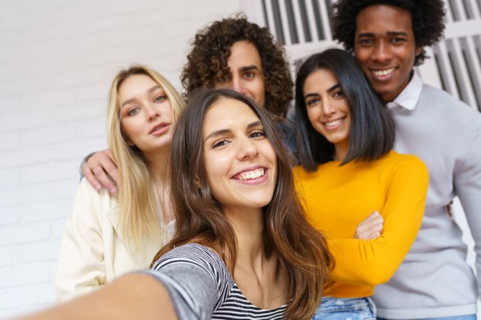 Happy group of friends posing for a selfie outside