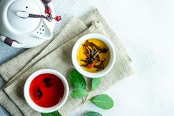 Two cups of tea on napkin with tea pot