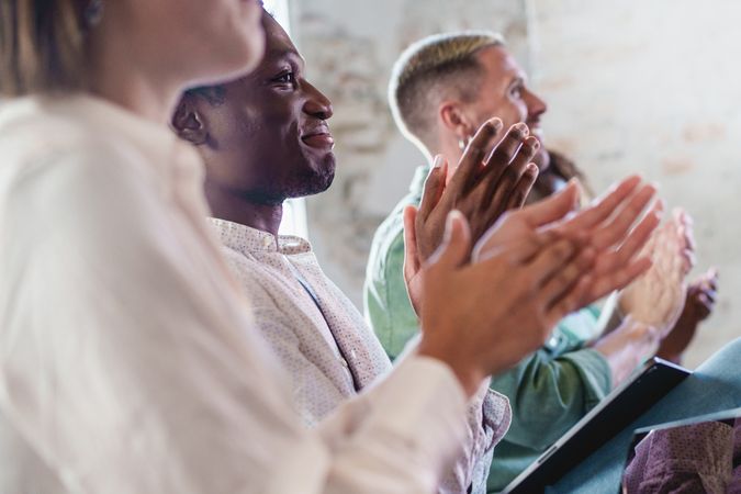 An informal group of business people listening to a speaker and applauding