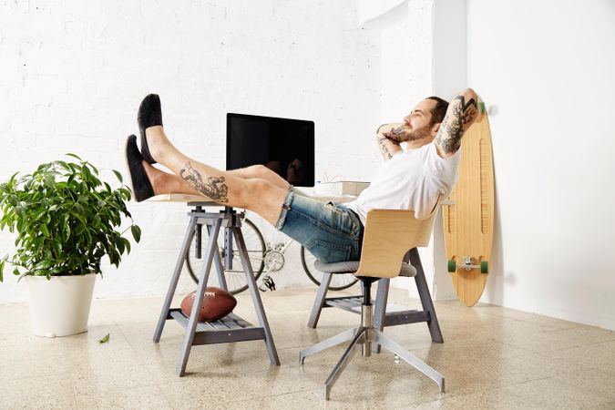 Man with legs on table in bright home office