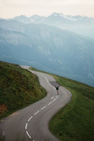 Scenic mountains view and man skateboarding on road